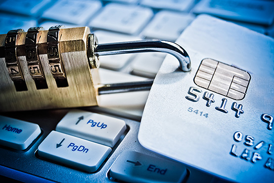 Padlock attached to a credit card sat on a computer keyboard.